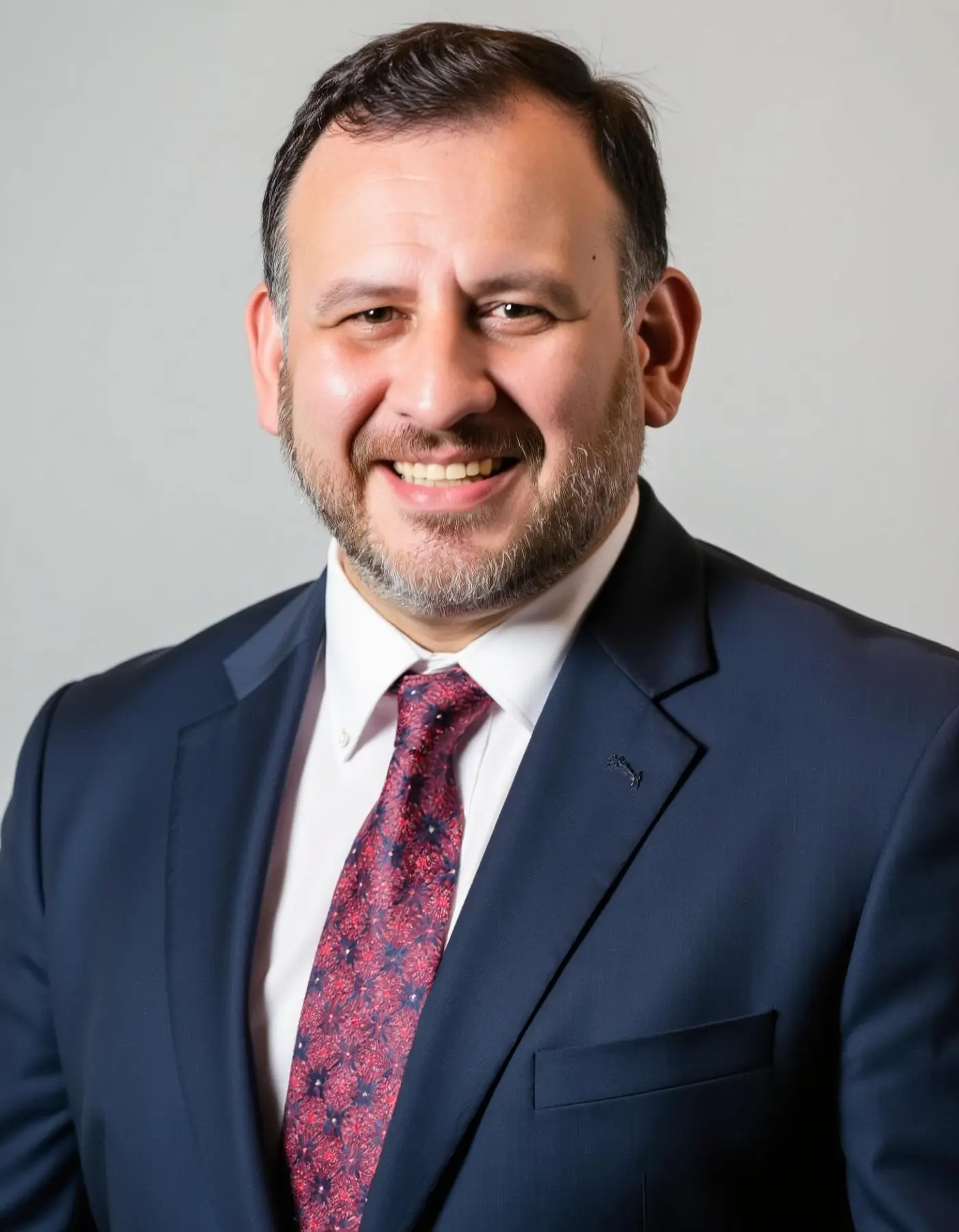 Ryan Morales in a navy suit and patterned tie